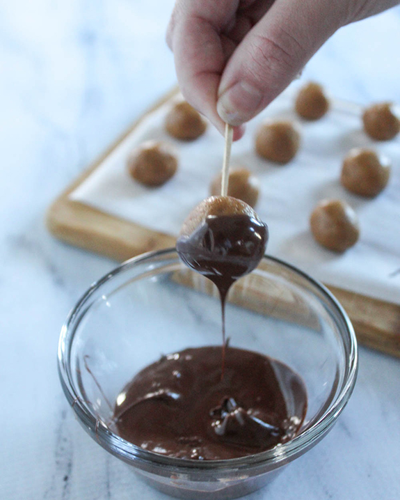 peanut butter ball coming out of the melted chocolate