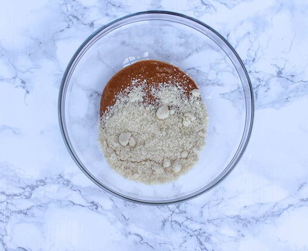 an overhead view of the almond flour and peanut butter in a mixing bowl