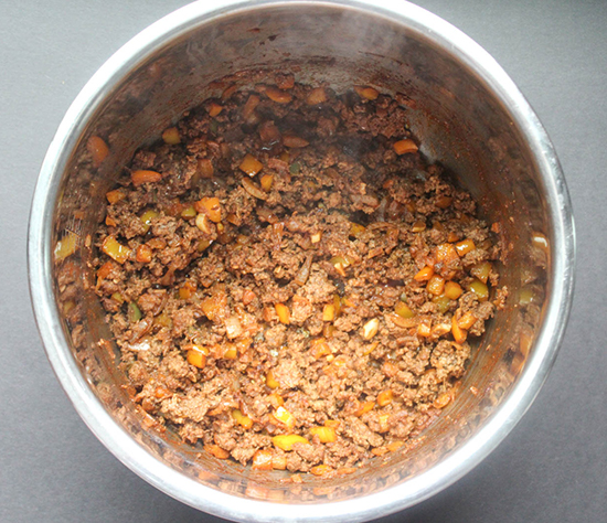 ground beef in a pressure cooker before the beans and tomatoes are added
