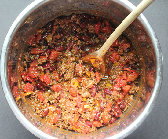 ground beef tomatoes beans and peppers mixed together in a pressure cooker 
