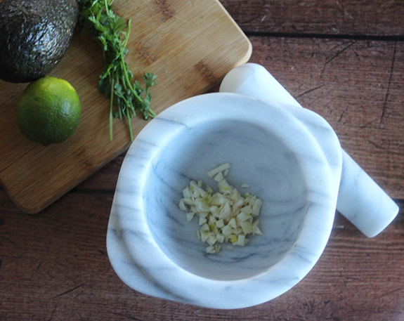 a picture of chopped garlic in a mortar bowl 