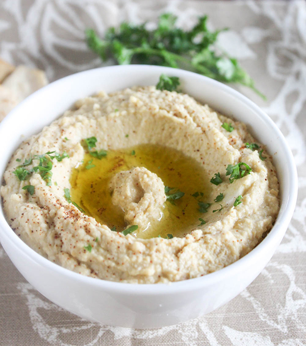 A close up picture of classic hummus in a white bowl