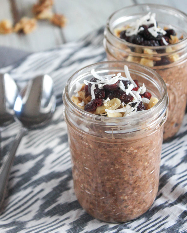 Two jars of Chocolate Banana Overnight Oats topped with walnuts, craisins and coconut