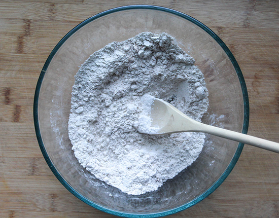 flour in a bowl with a wooden spoon