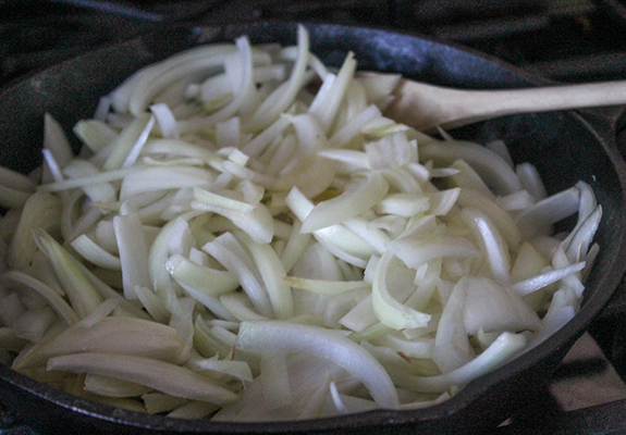 raw onions cooking in a skillet 