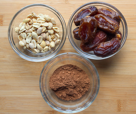 Peanuts, dates and coco powder in glass bowls