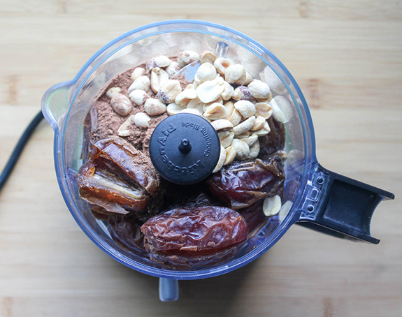 the ingredients in a food processor Peanuts, dates, cocoa powder