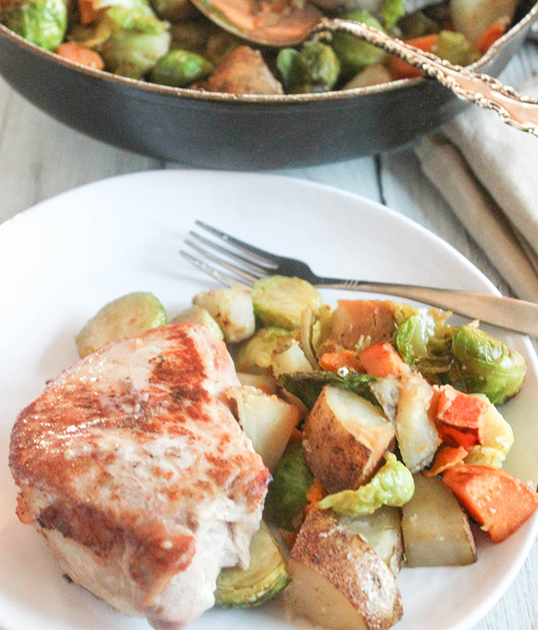 Pork chop and vegetables on a white plate