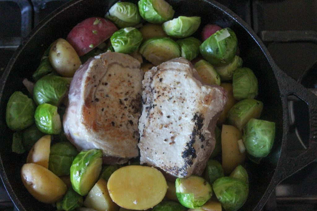 pork chops in a skillet with vegetables