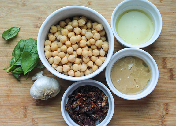 Ingredients: chickpeas, lemon juice, olive oil, sun dried tomatoes, garlic and basil in white bowls