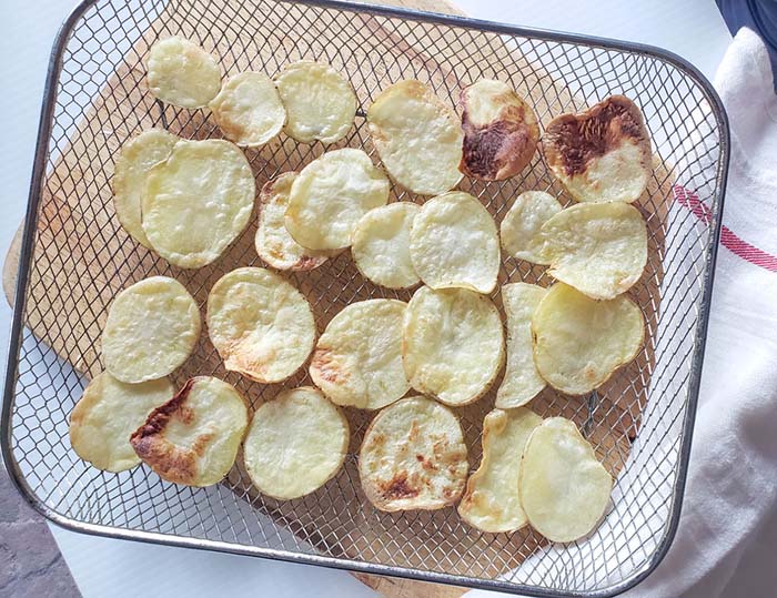 Potato slices cooked on an air fryer tray