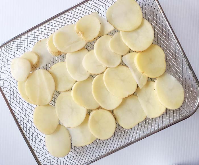 potato slices on an air fryer tray