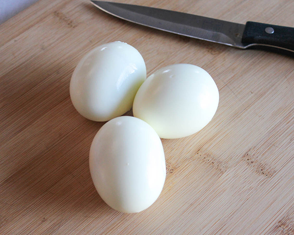 cooked and peeled eggs on a cutting board