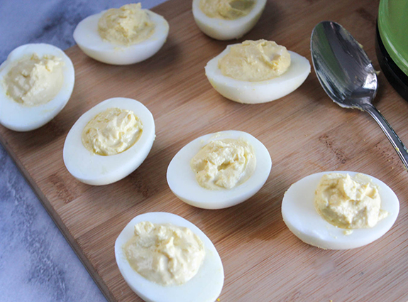 Egg whites filled with yolk mixture on a cuting board