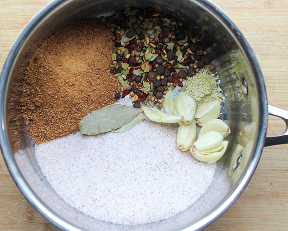 Ingredients in a pot: sea salt, garlic cloves, bay leaves, pickling spice and coconut sugar