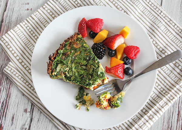 overhead view of quiche on a plate with fresh fruit