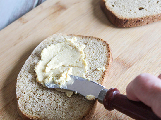 hummus spreading onto a slice of bread