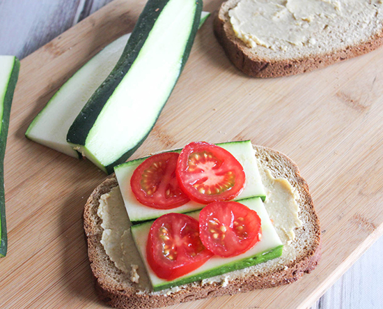 tomatoes and zucchini on top of a slice of bread