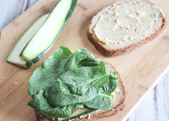 spinach on top of the veggies on the sandwich