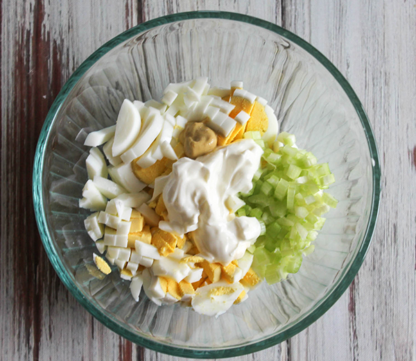 a bowl of chopped eggs, greek yogurt, mustard and horseradish not mixed