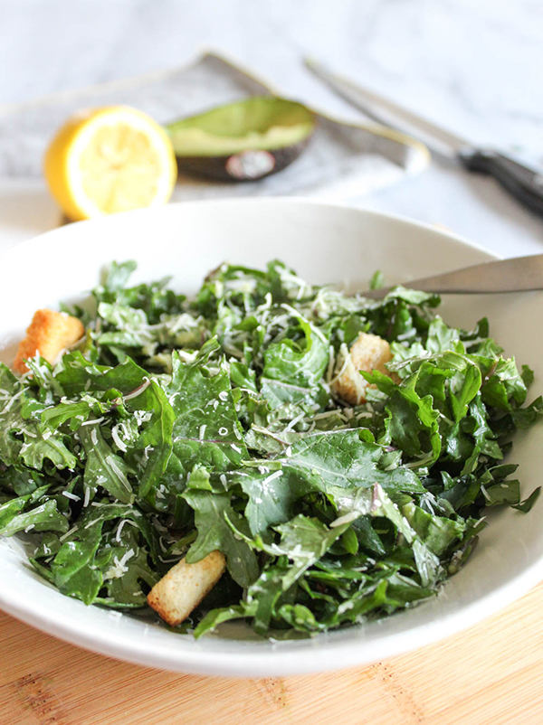 kale caesar salad in a bowl with a fork