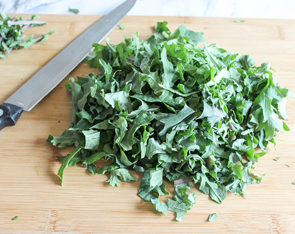 kale on a cutting board with  kinfe