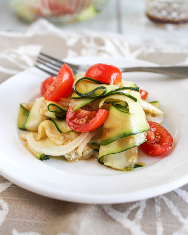 zucchini ribbon salad on a white plate with a fork