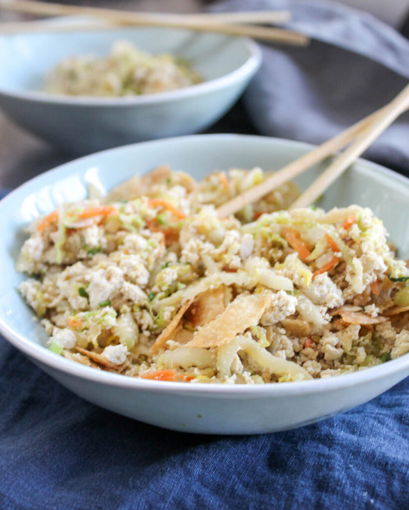 a close up picture of an egg roll in a bowl with chop sticks