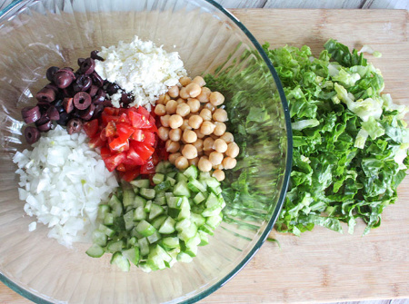 The salad ingredients in a bowl with lettuce on the side