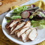 sliced jerk chickenon a plate with a salad