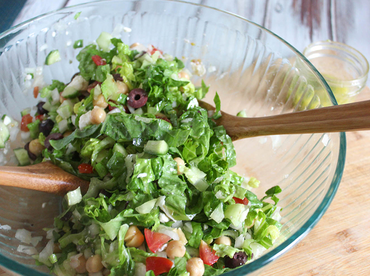 salad in a glass bowl with two spoons