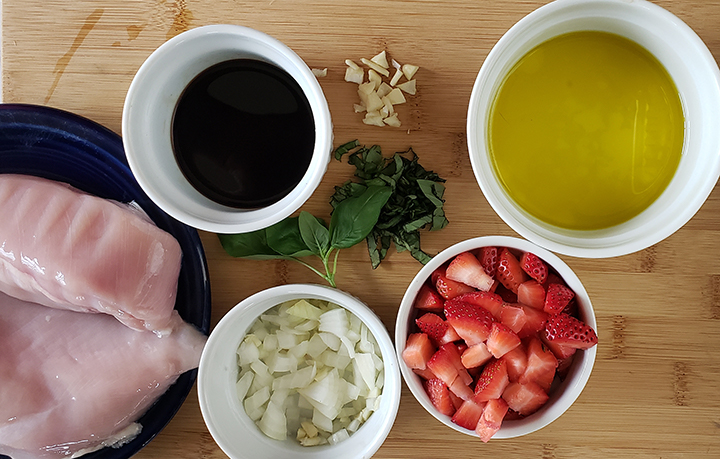 the ingredients chicken balsamic vinegar, oil, garlic onions, basil and strawberries