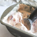 a close up of ice cream in a pan with a scoop