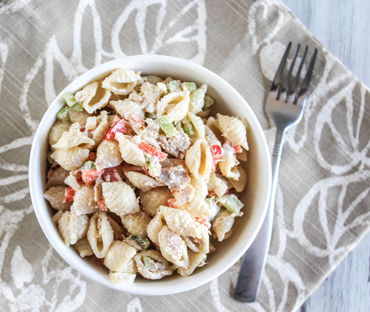 A view looking down at tuna mac salad in a white bowl with a fork