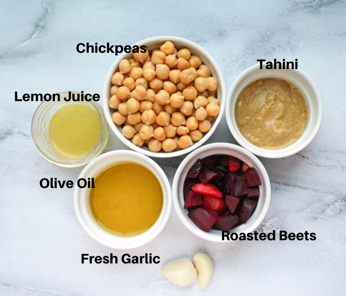 Roasted Beets Humus Ingredients in white bowls: chickpeas, tahini, roasted beets, garlic cloves, olive oil, lemon juice