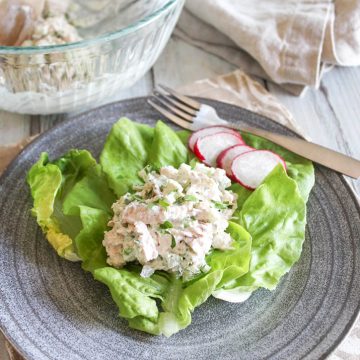 chicken salad on a plate with radishes and a fork on the side