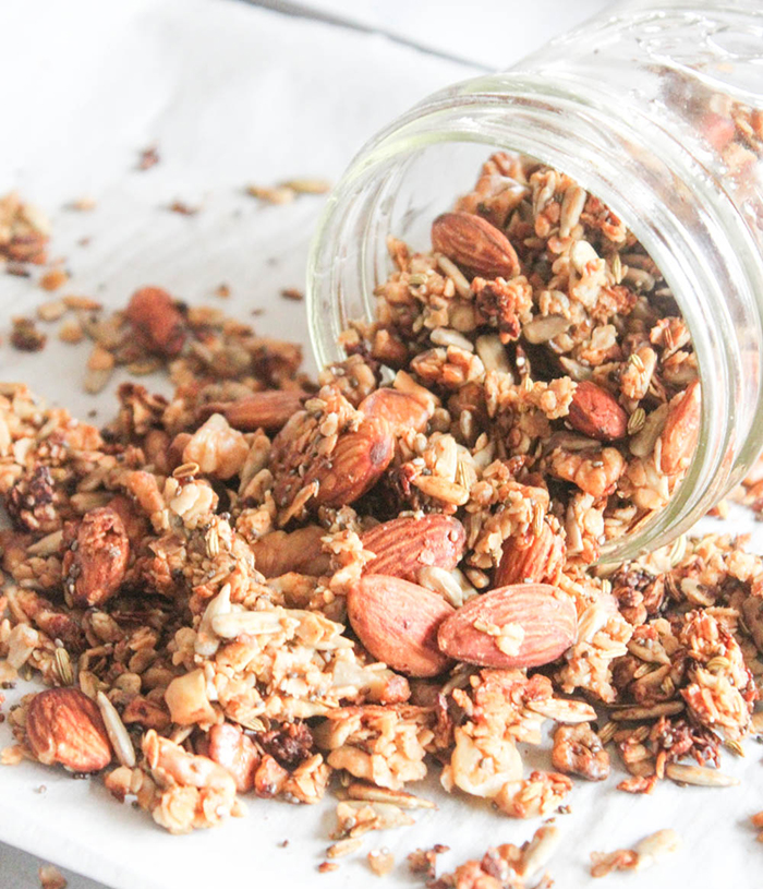 a jar of granola spilled onto its side with granola pouring out 