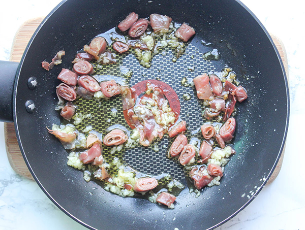 prosciutto garlic and oil cooking in a skillet 