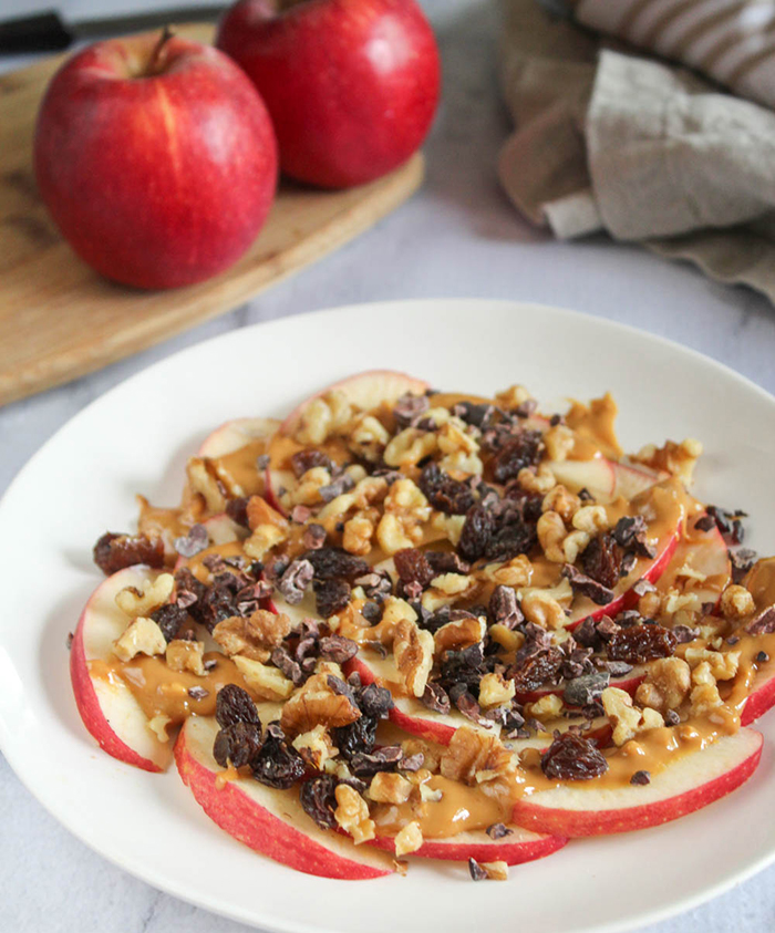 apple nachos oa plate with two apples in the background