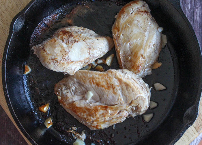 chicken cooking  in a pan with garlic