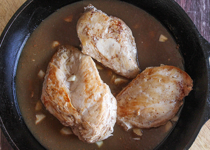 CHicken in a skillet with a brown sauce