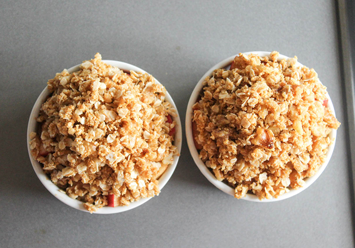 two ramekins topped with crumb mixture on  a baking sheet