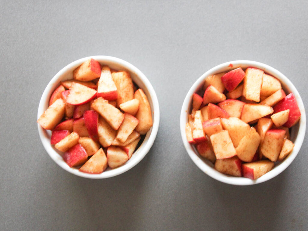 two white ramekins filled with apple pieces