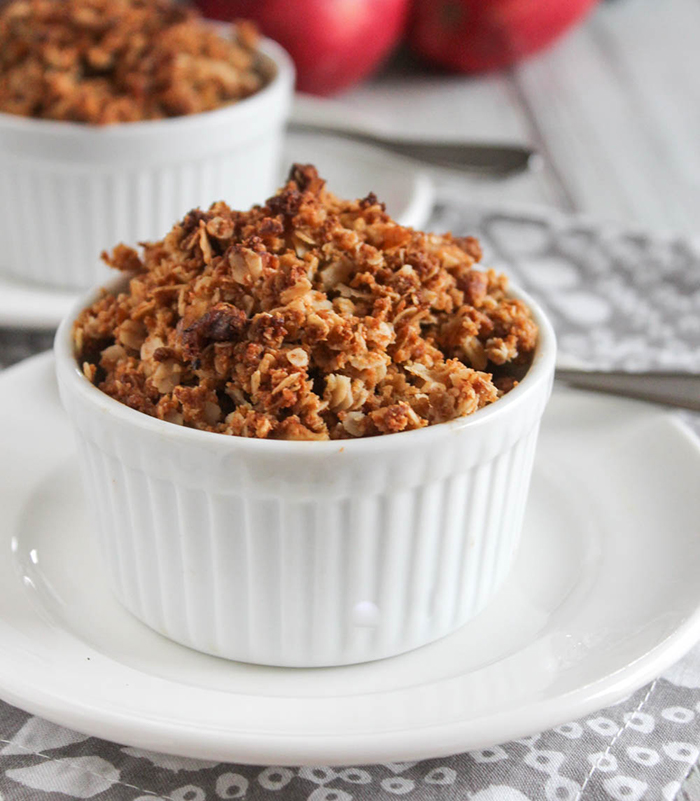 mini apple crisp in a white ramekin dish on a white plate