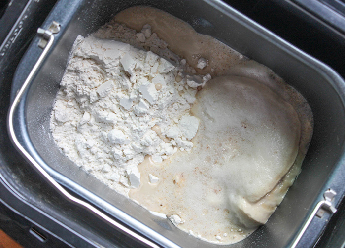 the ingredients for pizza dough in a bread machine bowl