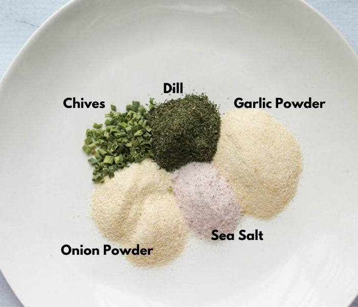 The ingredients on a plate: dried chives, Dill, garlic powder, onion powder, sea salt