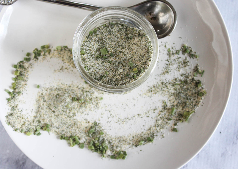 An overhead view of the spice blend in a jar with a spoon on the side