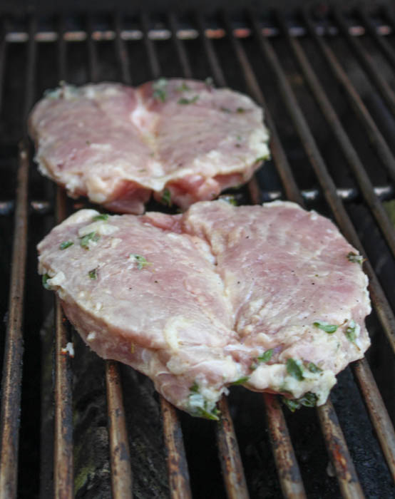 bonelesss pork chops cooking on a grill