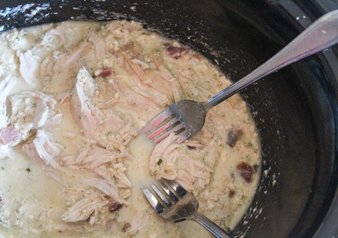 two forks in a slow cooker with chicken