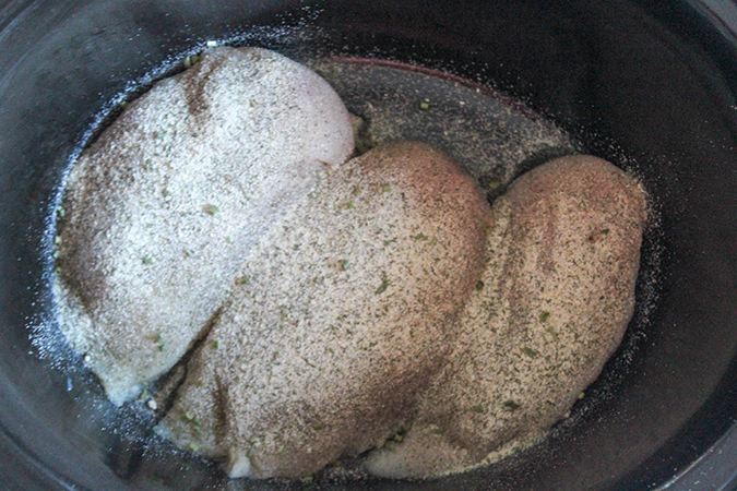 three boneless chicken breasts in a slow cooker